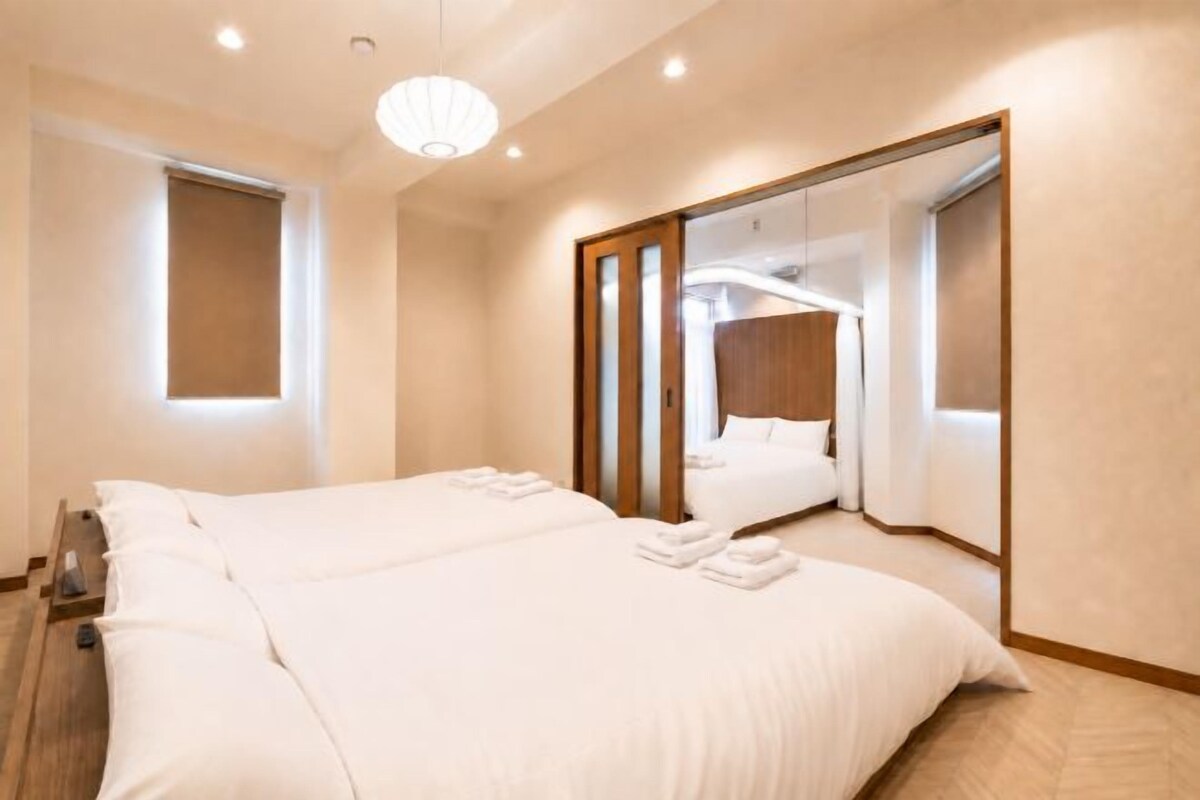 A hotel room with a large bed, a mirror, and a window.