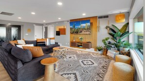 A modern living room with a grey sofa, patterned rug, and various plants. - Horizon Haven•Hot Tub•Views•Game Room•Speakeasy (Tucson)