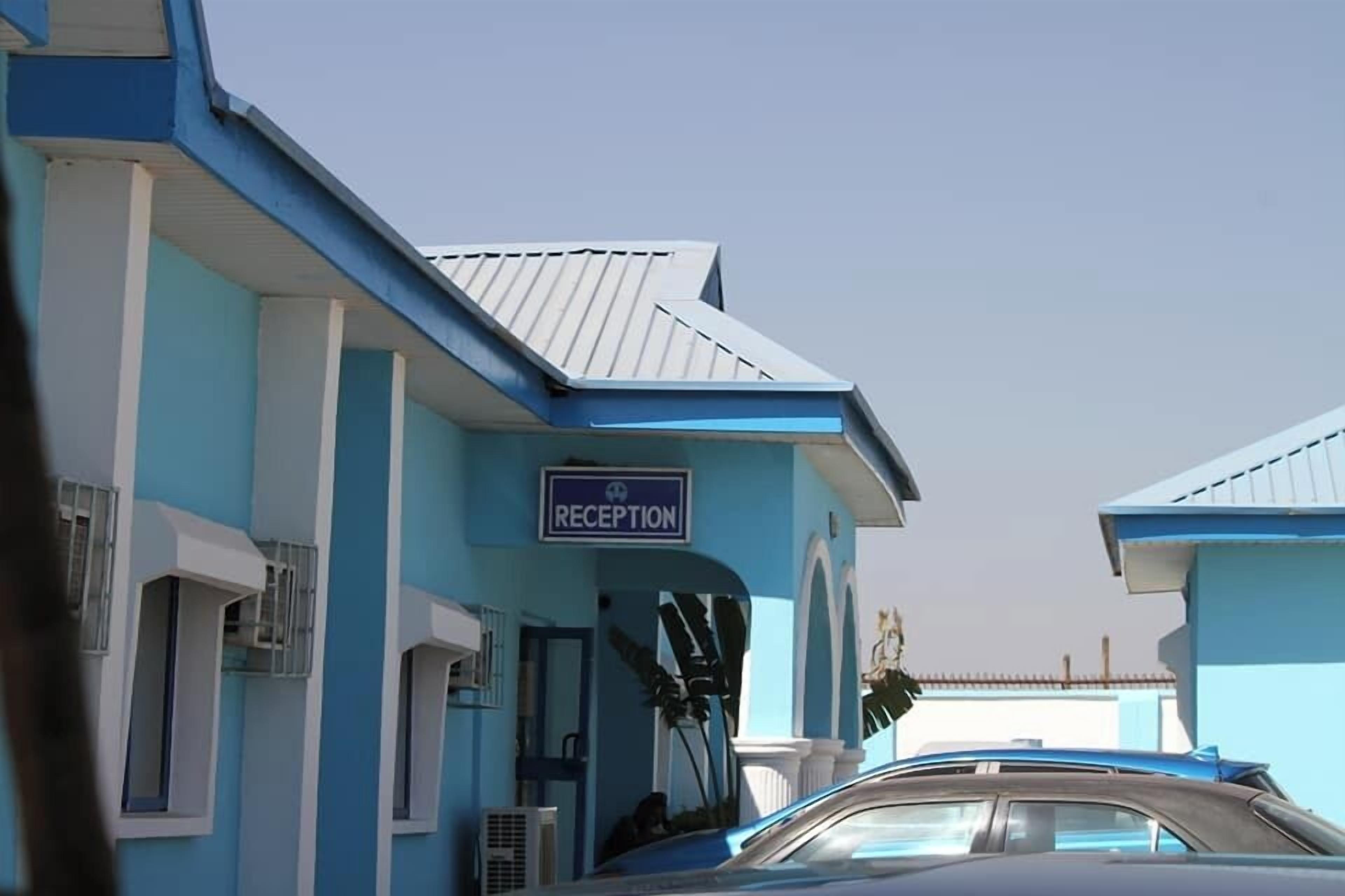 A building with a reception area, a blue and white color scheme, and a parked car.