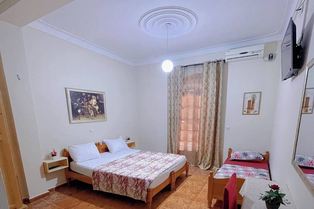 A room with two beds, a desk, and a chair.