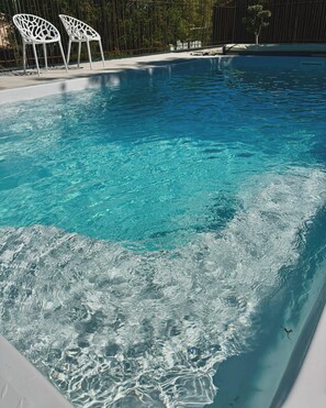 A clear swimming pool with two white chairs and a small tree in the background. - New villa with a pool in Rosieres, Ardèche; accommodates up to 10 people (Rosières)