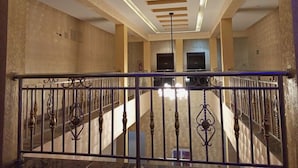 Ένας ευρύχωρος εσωτερικός χώρος με ψηλό ταβάνι, μια κεντρική σκάλα και ένα μοντέρνο σχέδιο.