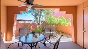 A patio with a round glass table, four chairs, and a ceiling fan. - CASA FAMILIA - 1st floor 2-bedroom unit (Phoenix)