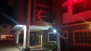 A two-story house with a balcony, a driveway, and a parked vehicle. - Jay Hiltin Hotel (Kaduna)