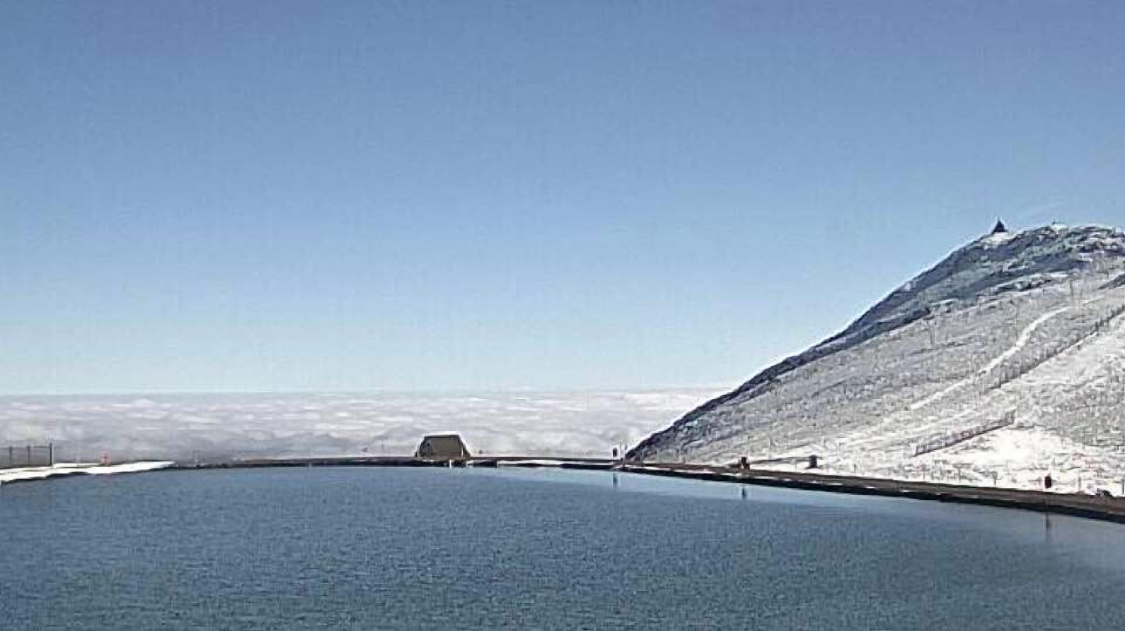 A large body of water with a snow-covered mountain in the background.