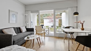 Un salon moderne comprenant un canapé, une table basse et un coin repas avec des chaises et une table.