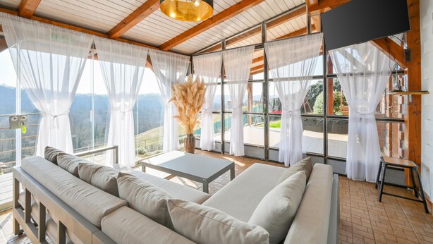 A room with a sofa, a table, and a view of the outdoors. - Beautiful home in Falinic Breg with sauna (Falinic Breg)