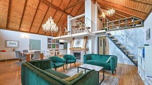 A spacious living area with a high ceiling, wooden beams, a fireplace, and a staircase leading to an upper level. - Beautiful home in Falinic Breg with sauna (Falinic Breg)