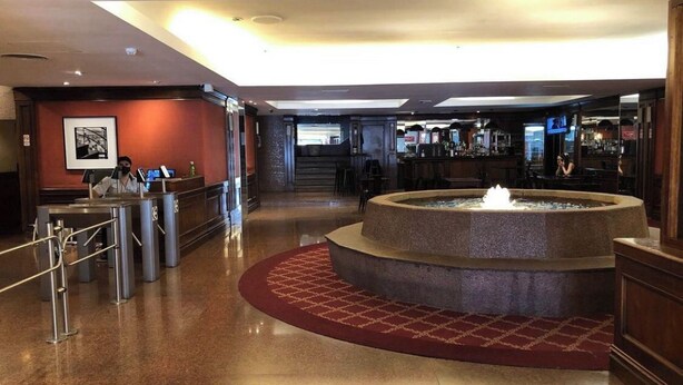 Un vestíbulo con una fuente central, una recepción y una zona de bar.