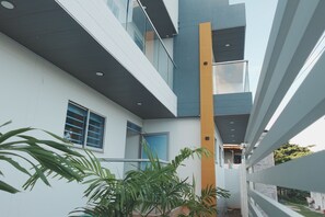 A modern building with a white exterior, a balcony, and a vertical yellow accent. - Saphire Apartments (San Andrés)