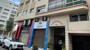 A multi-story building with a commercial ground floor, featuring a sign for 'Opportunities Hunter' and 'Lughelle Residence 40'.