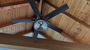 Ein Deckenventilator mit Holzbalken und einem Oberlicht.
