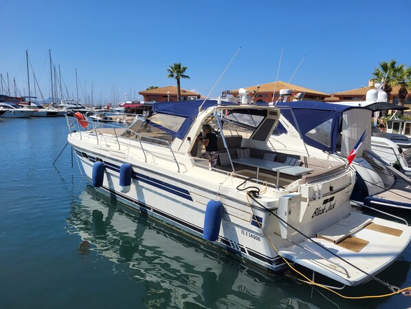 A marina with boats docked, a clear sky, and buildings with tiled roofs in the background. - Boat 'Port De Saint-Raphaël' with Sea View and Private Terrace (Saint-Raphaël)