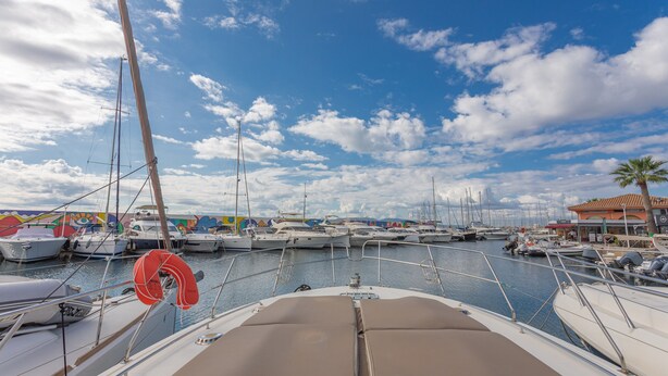 A marina with multiple boats docked, a clear sky, and a building with a red roof in the background. - Boat 'Port De Saint-Raphaël' with Sea View and Private Terrace (Saint-Raphaël)