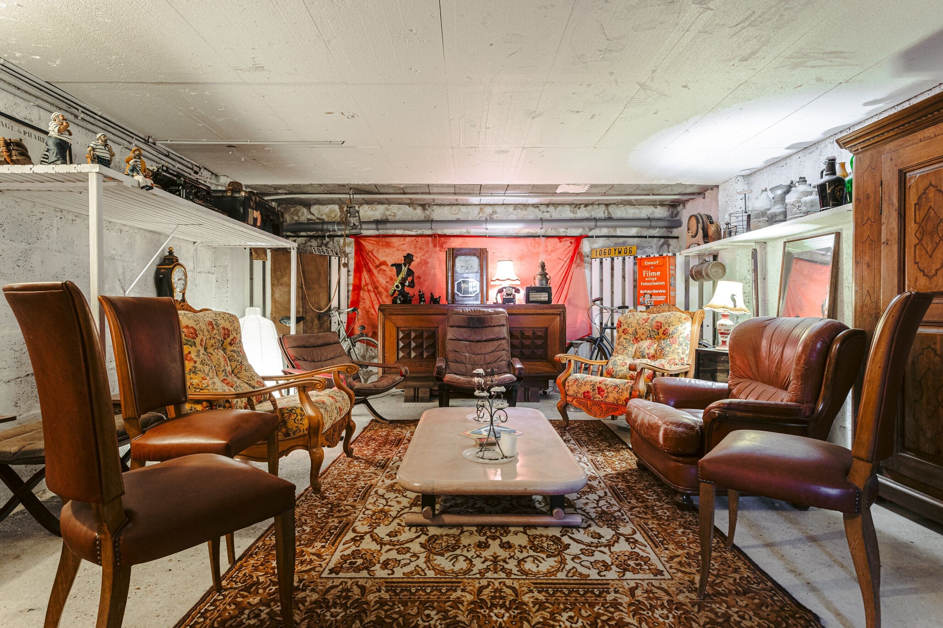 Un salon de style vintage avec des fauteuils en cuir, un tapis à motifs et une cheminée.