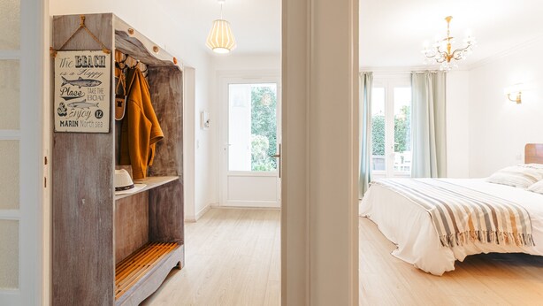 Un dormitorio con cama, armario de madera, un cartel y una ventana.
