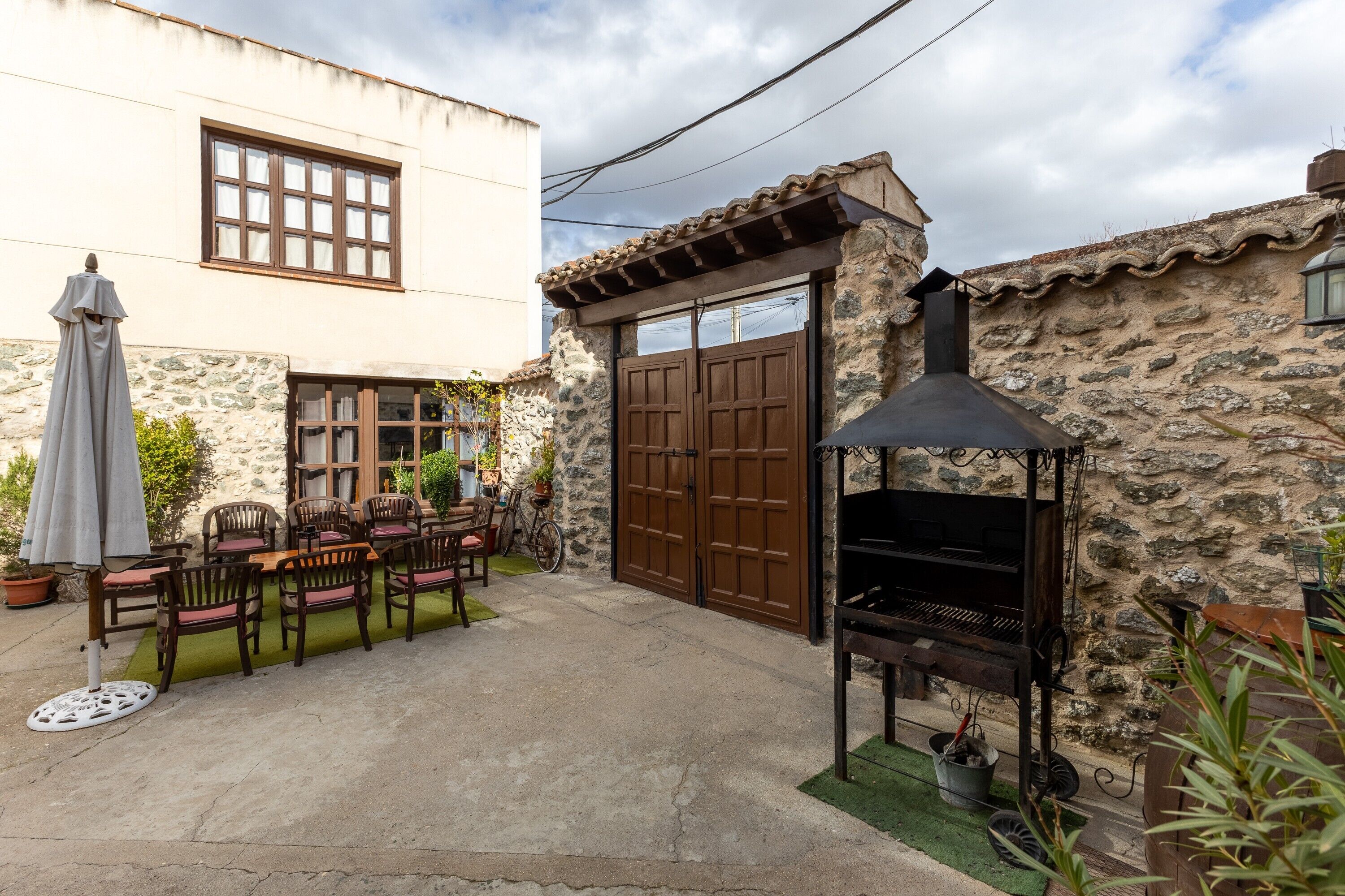 Eine Terrasse mit Grill, Stühlen und Tisch.