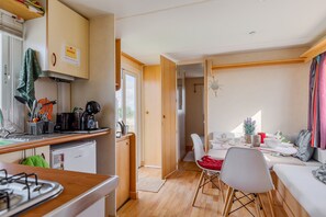 A compact living space with a kitchenette, dining area, and a sofa.
