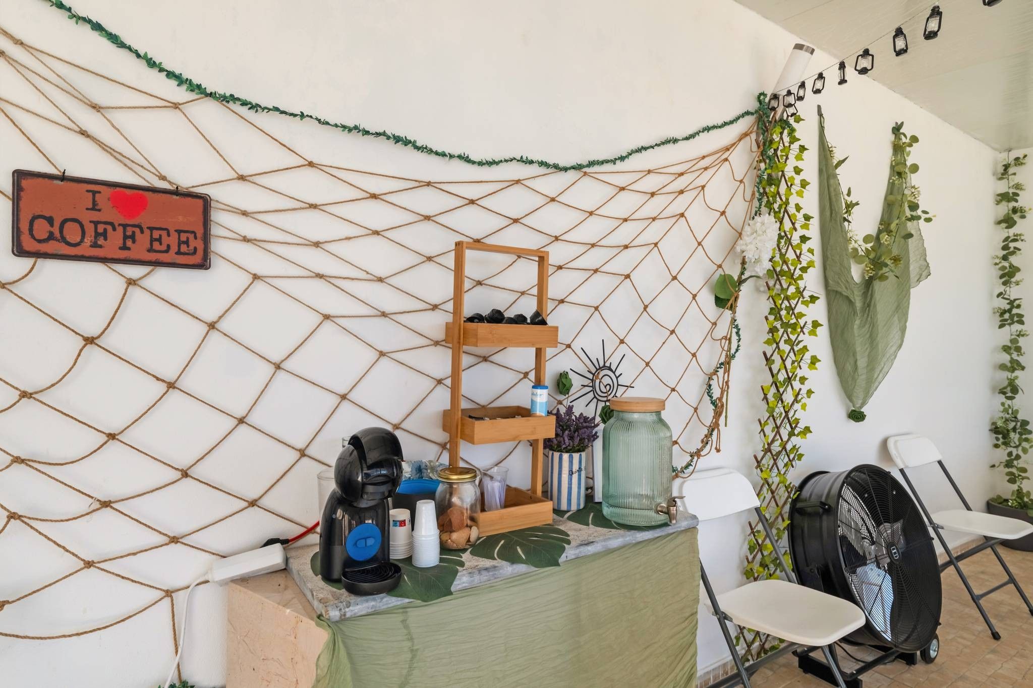 Un angolo accogliente con la macchina del caffè, un cartello e diversi contenitori.