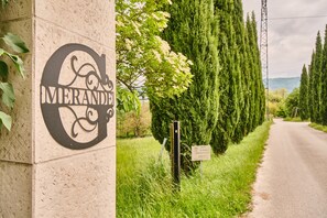 A sign with the word 'MERANDINE' on a building, a road with trees, and a grassy area. - Holiday Home 'Chateau De Merande' with Mountain Views, Private Terrace and Wi-Fi (Arbin)