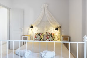 Une chambre à coucher avec un lit à baldaquin, des tables de chevet et une balustrade blanche.