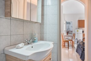 Une salle de bain équipée d’un lavabo, d’un miroir et d’articles de toilette.
