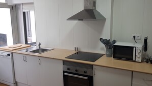 Een moderne keuken met een ingebouwde oven, magnetron en gasfornuis.