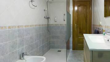 A bathroom with a shower, a sink, and a toilet.
