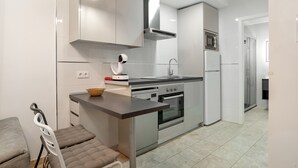 Una cocina moderna con electrodomésticos de acero inoxidable, horno empotrado y microondas.