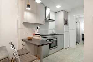 Una cocina moderna con electrodomésticos de acero inoxidable, horno empotrado y microondas.