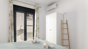A bedroom with a bed, a wardrobe, a ladder, and an air conditioning unit. - Apartment 'Bellamar 6 Apartamento 2Dormitorios' with Wi-Fi and Air Conditioning (Barbate)