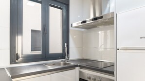 A modern kitchen with stainless steel appliances, a window with blinds, and a built-in oven. - Apartment 'Bellamar 6 Apartamento 2Dormitorios' with Wi-Fi and Air Conditioning (Barbate)