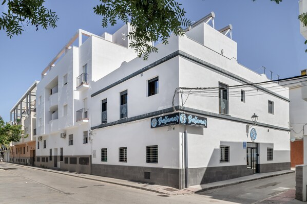 Un edificio blanco con balcones y un cartel que dice 'Bellamar'.