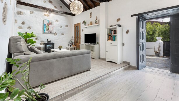 A modern living room with a sofa, TV, and decorative items. - Vacation Home 'Casa Doña Carmen' with Mountain View, Private Terrace and Wi-Fi (Betancuría)