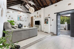 A modern living room with a sofa, TV, and decorative items.