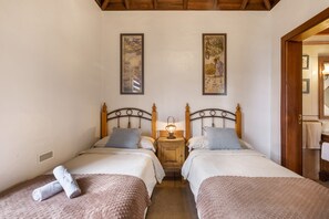 A double room with two beds, a nightstand with a lamp, and two framed pictures on the wall. - Apartment 'Aljibe 1' with Mountain View, Shared Pool and Wi-Fi (Las Tricias)