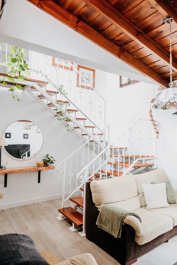 A staircase with white railings and wooden steps, a round mirror, and a sofa with cushions. - Casa Rural 'Casa Rural Kiko' with Mountain Views, Private Terrace & Wi-Fi (Icod de los Vinos)