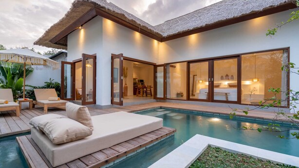 A modern house with a pool, wooden deck, and thatched roof. - Villa Lounes 1 (Tabanan)