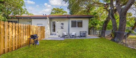 A house with a fenced backyard, a patio with outdoor furniture, and a garage.