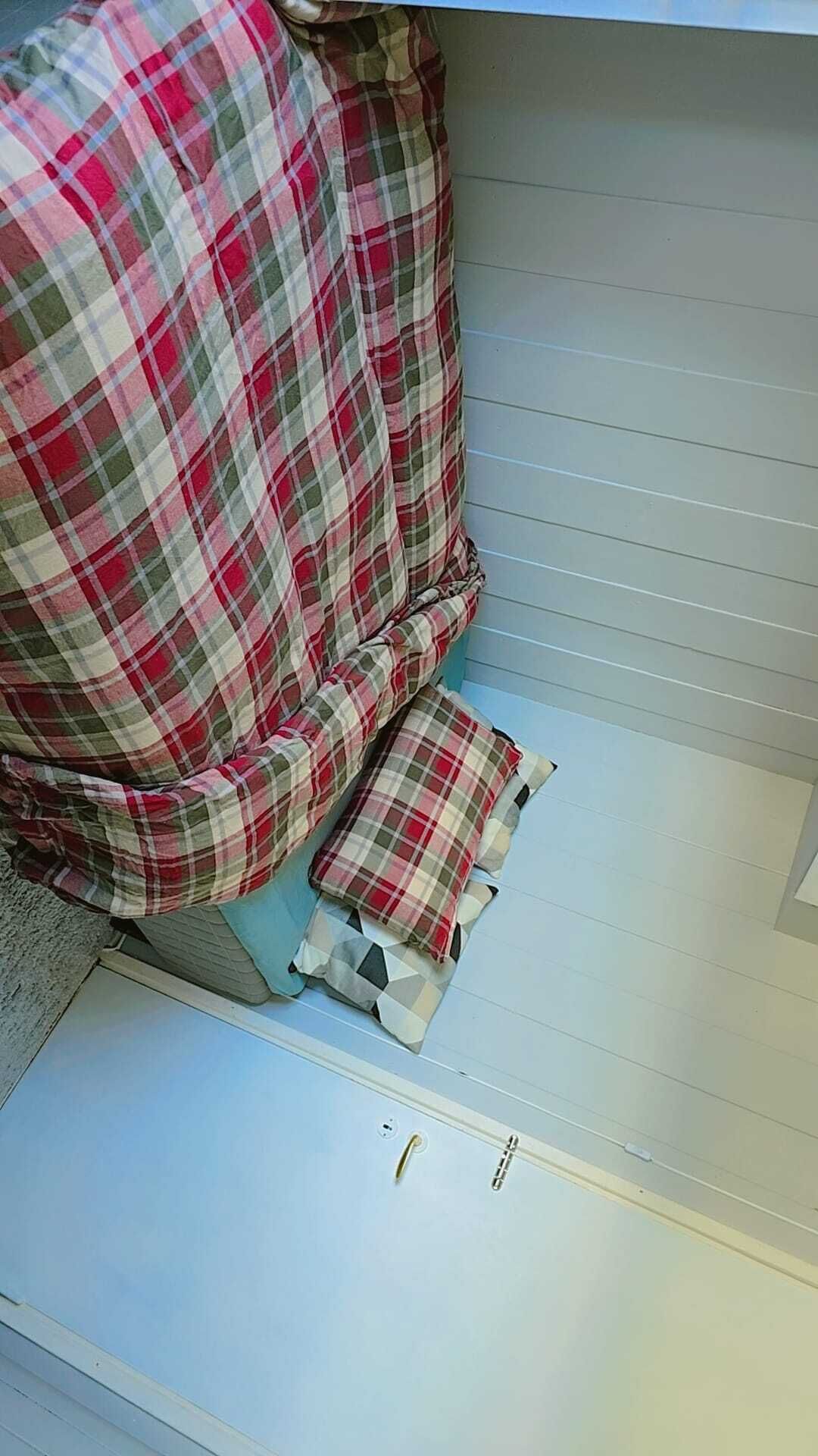 Un bany amb un lavabo blanc, un mirall i un tapet de bany vermell i blanc a quadres.