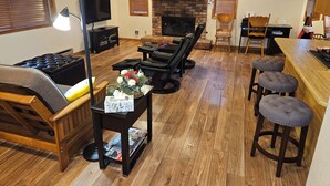 A cozy living room with a fireplace, wooden furniture, and a bar area. - Garden Cabin with Fenced Yard and AC (Pinetop)