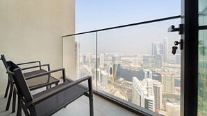 A balcony with a view of a cityscape, including tall buildings and a river.