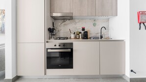 Una cocina moderna con horno empotrado, microondas y campana extractora de acero inoxidable.