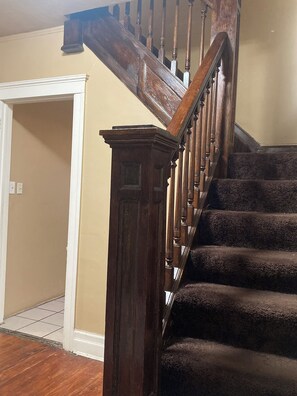 Staircase leads to an upper floor with carpeted steps and a handrail.