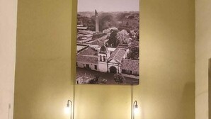 A waiting area with a bench, two tables, and a wall-mounted light fixture. - COMALITAS HOTEL Y CAFE (Comala)