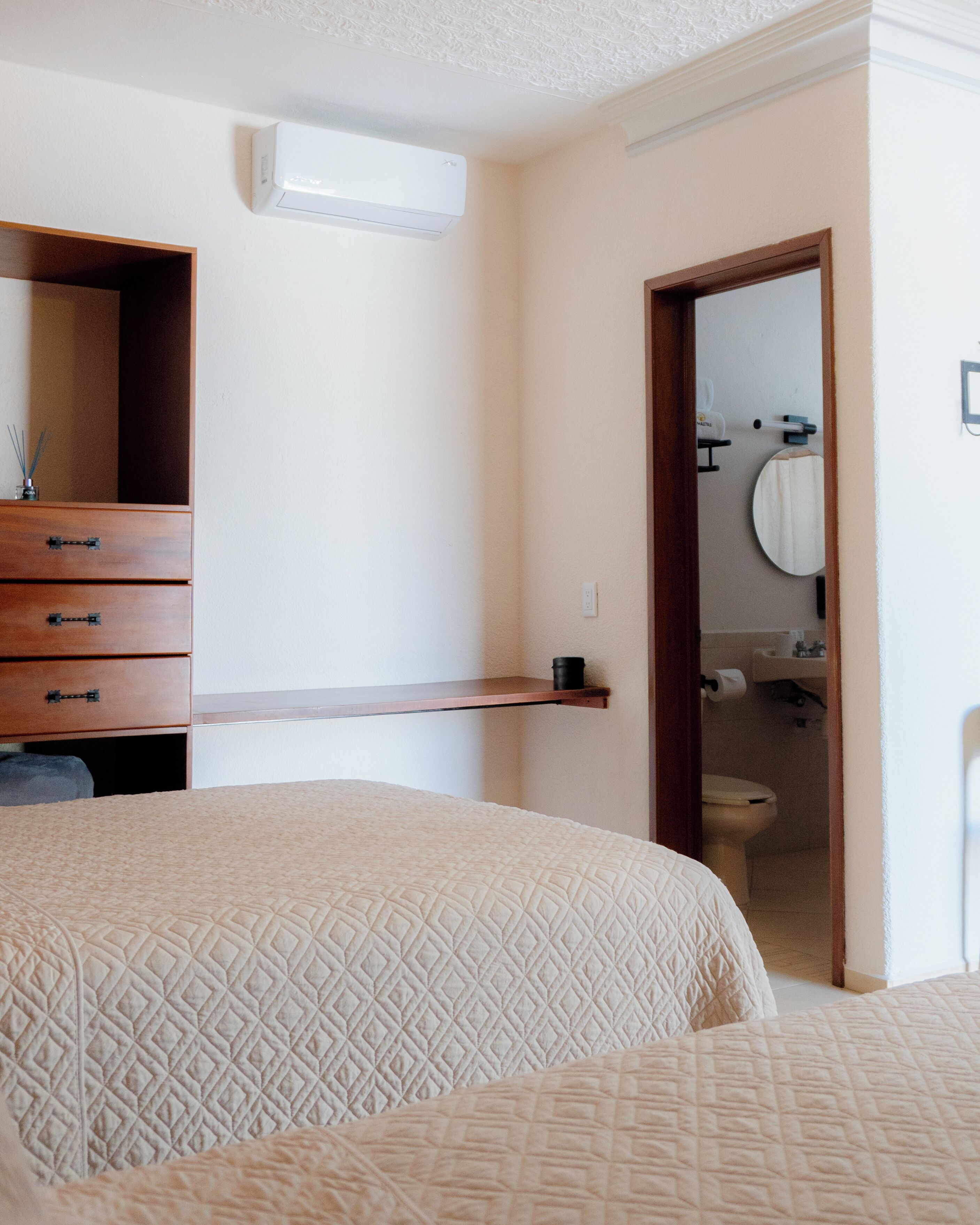 Un dormitorio con cama, cómoda y espejo.