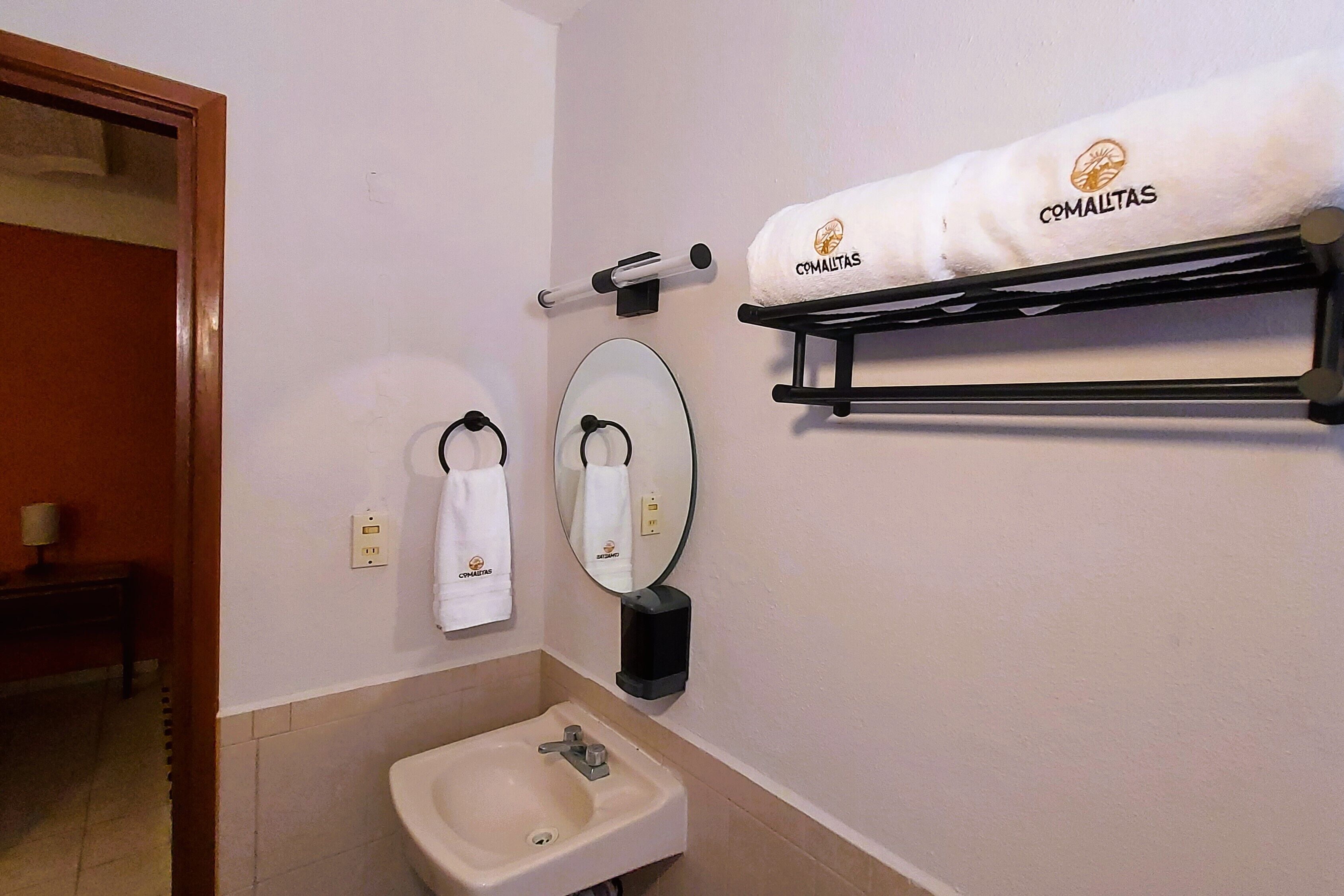A bathroom with a sink, towel rack, and a mirror.