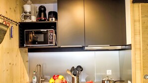 A modern kitchen with a stainless steel microwave, a sink, and a wooden countertop.