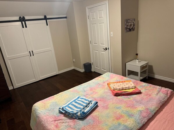A bedroom with a bed, a small bedside table, a wardrobe, and a door. - Courtland Heaven Retreats (Courtland)