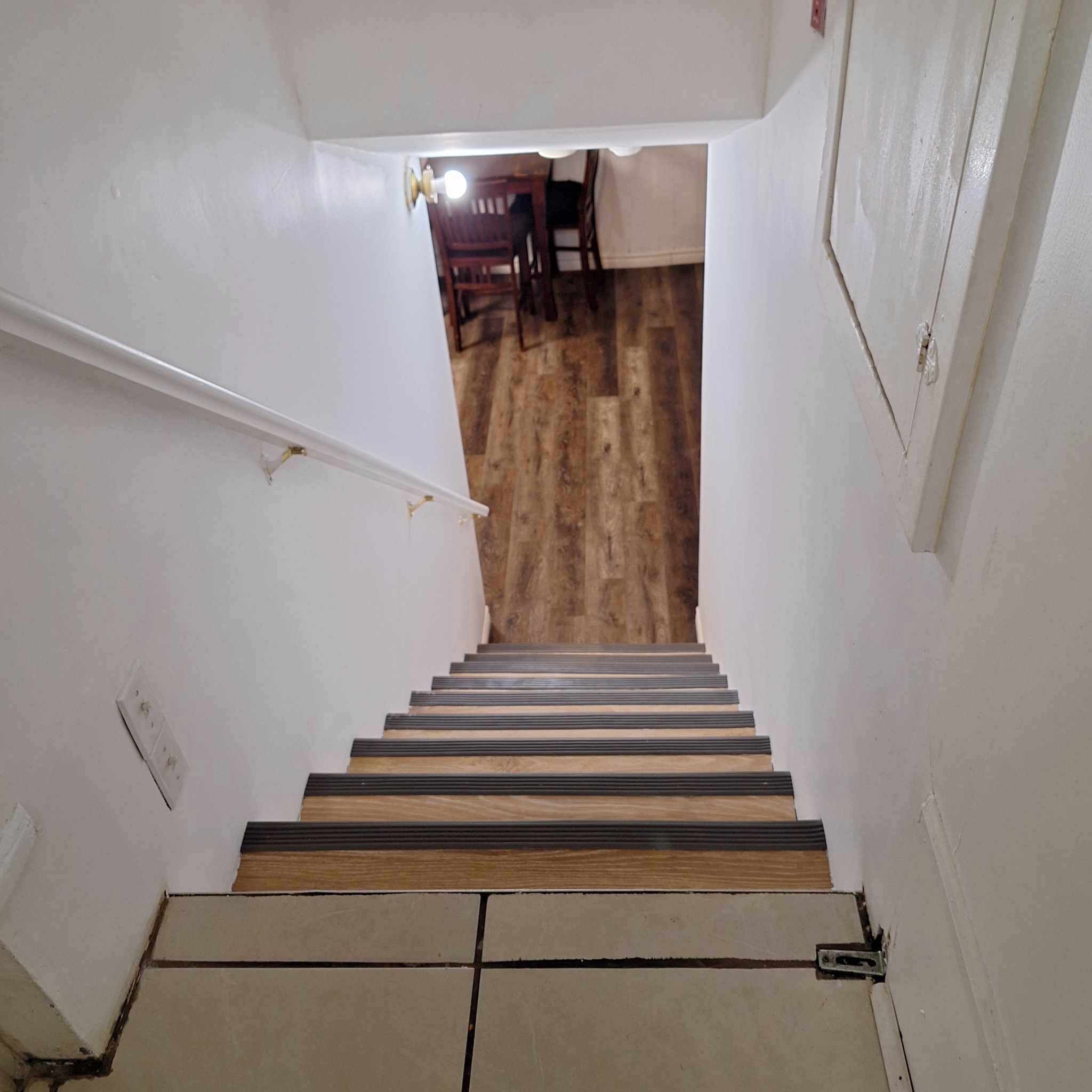 Un escalier avec des marches en bois menant à une pièce dont le plancher est également en bois.